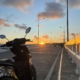 Eye-catching image of a motorbike silhouetted against the vibrant colors of the sunset at Catangnan Bridge, Siargao.