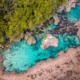 A stunning view of the Magpupungko Rock Pools in Siargao, with turquoise waters framed by jagged rocks, reflecting the clear blue sky.