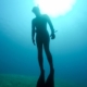 A freediver explores the mysterious depths of Siargao's blue sea, showcasing the peaceful interaction between humans and the underwater world.